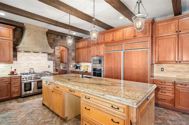 a kitchen with kitchen island granite countertop a sink stove and refrigerator