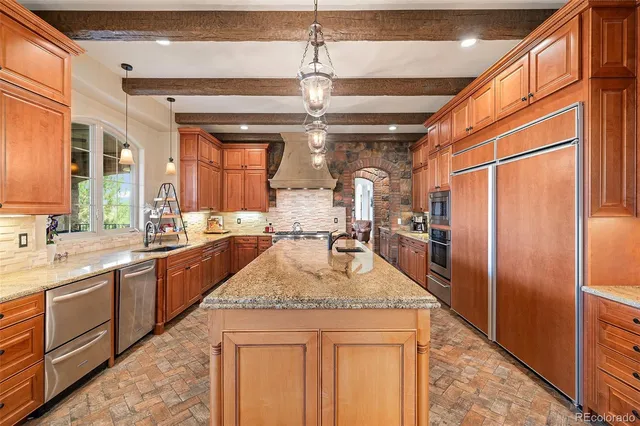 a kitchen with stainless steel appliances granite countertop a sink refrigerator and cabinets