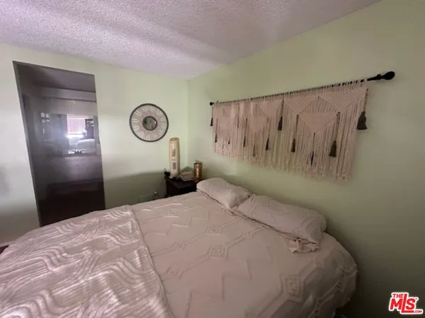 a bedroom with a bed and a wall painting
