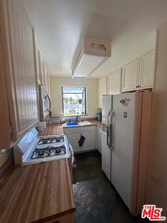 a kitchen with stainless steel appliances granite countertop a refrigerator stove and sink