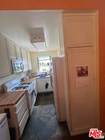 a kitchen with a refrigerator and a stove