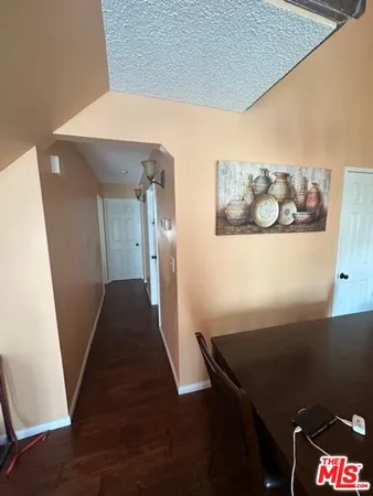 a view of a hallway to a livingroom with furniture