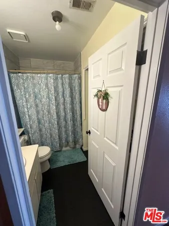 a bathroom with a sink a toilet a mirror a vanity and a window