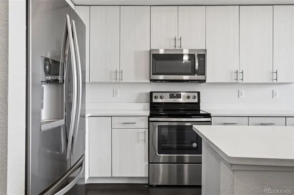 a kitchen with stainless steel appliances and white cabinets