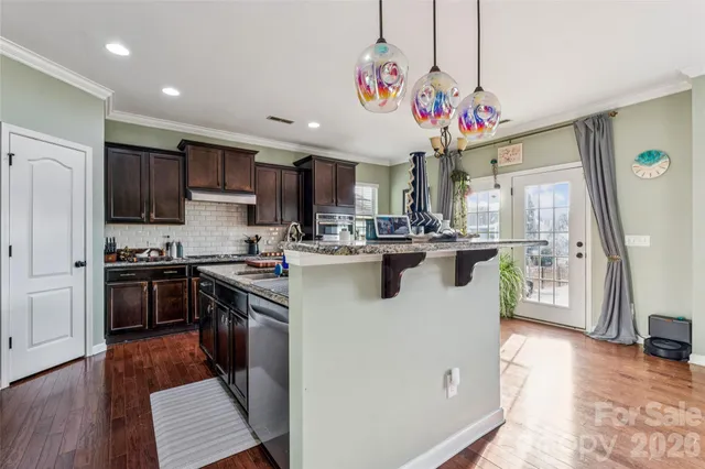 a kitchen with stainless steel appliances granite countertop a sink a stove and a refrigerator