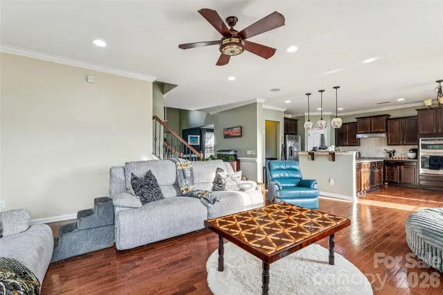 a living room with furniture kitchen view and a chandelier