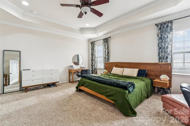 a spacious bedroom with a bed and ceiling fan