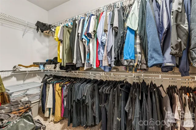 a view of walk in closet with clothes