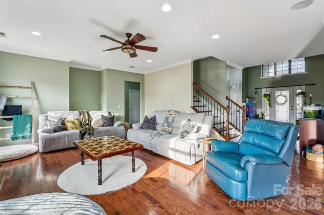 a living room with furniture kitchen view and a wooden floor