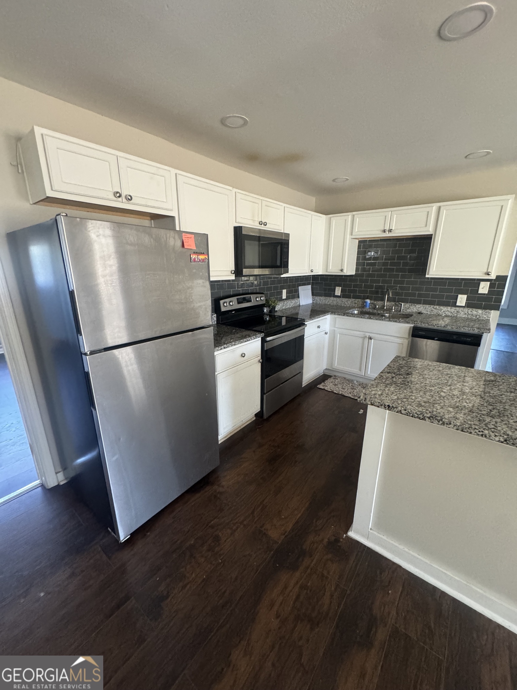 5205 Heather Lane Atlanta, GA 30349 - Photo 11 of 14 a kitchen with a refrigerator a stove top oven a sink and cabinets