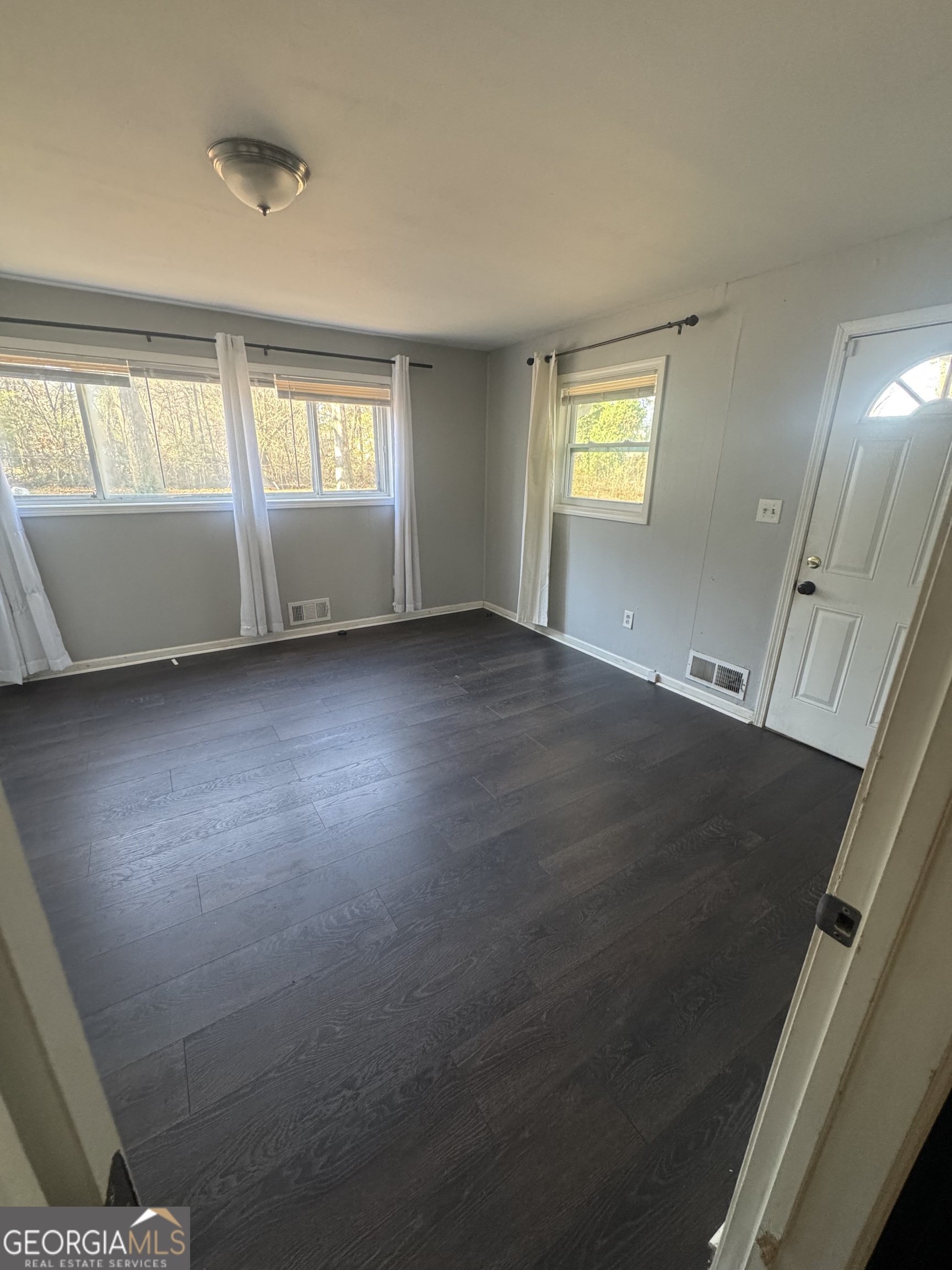 5205 Heather Lane Atlanta, GA 30349 - Photo 14 of 14 a view of an empty room with a window and wooden floor