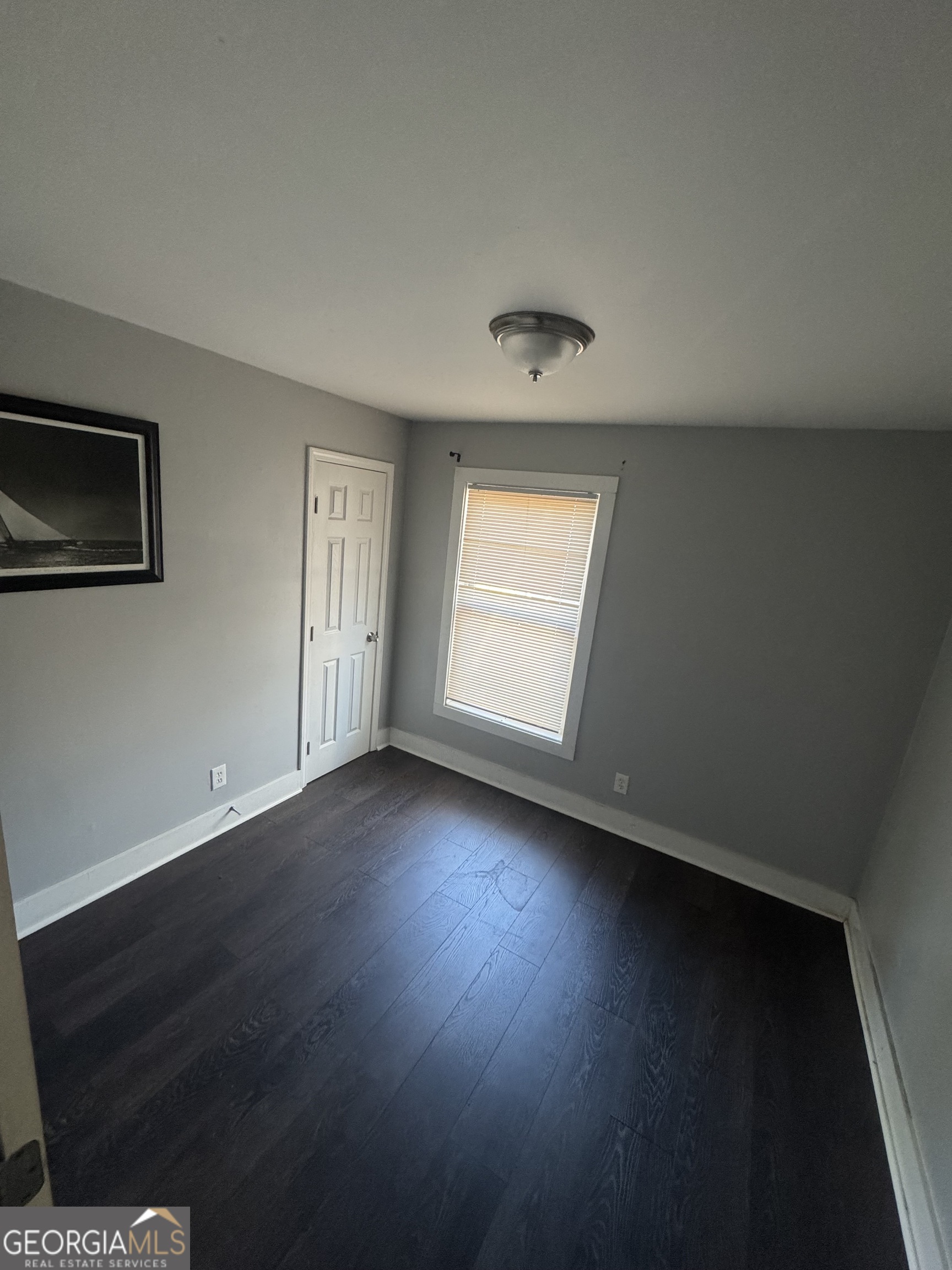 5205 Heather Lane Atlanta, GA 30349 - Photo 6 of 14 a view of an empty room with wooden floor and a window