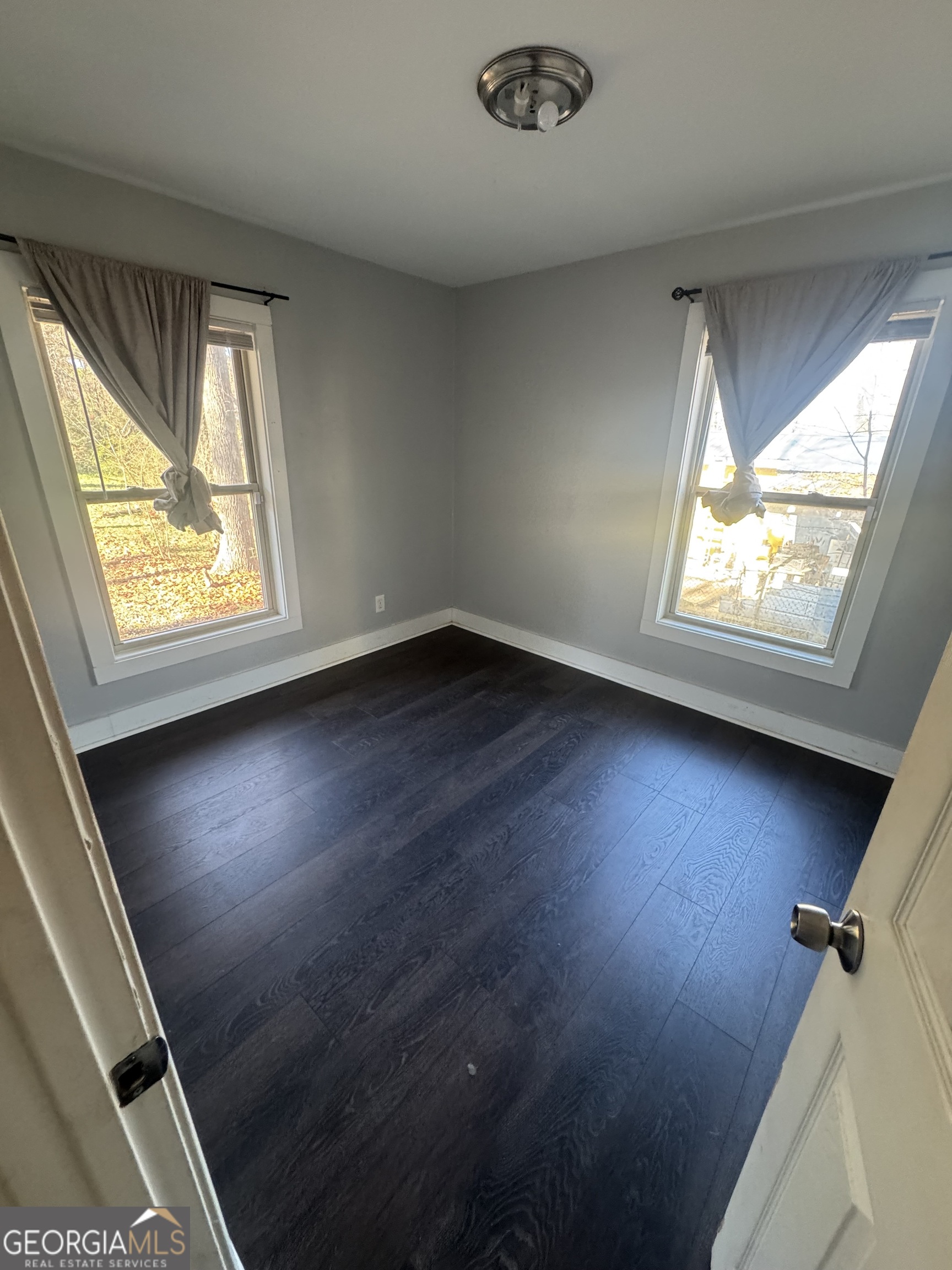 5205 Heather Lane Atlanta, GA 30349 - Photo 7 of 14 an empty room with wooden floor and windows