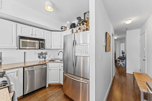 a kitchen with white cabinets and stainless steel appliances