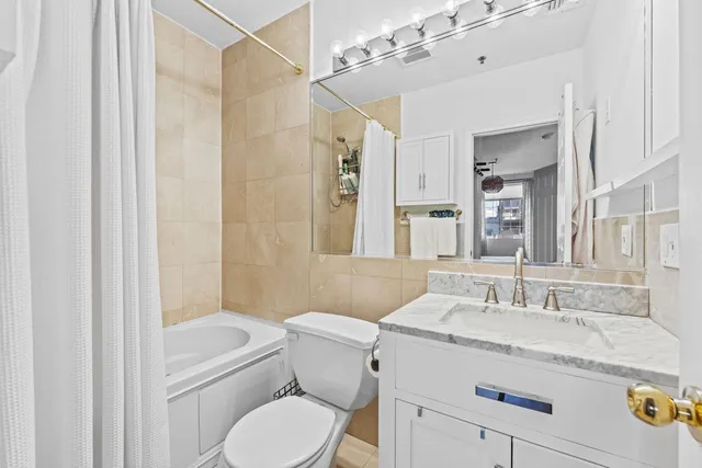 a bathroom with a granite countertop sink toilet a mirror a vanity and shower