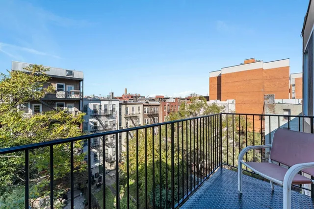 a view of a balcony with wooden chairs