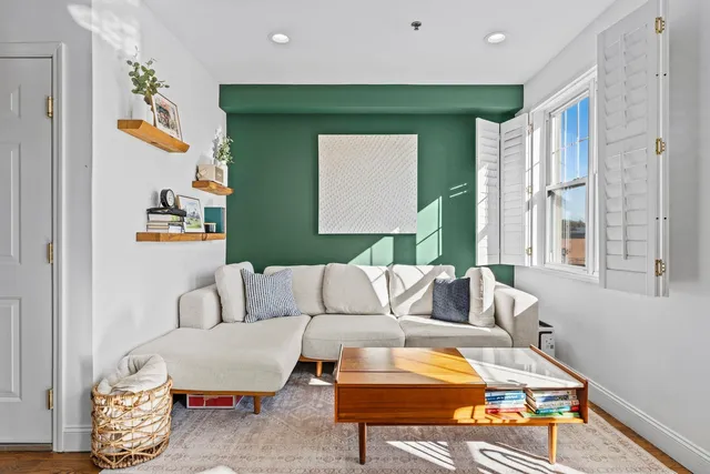 a living room with furniture and a painting on the wall