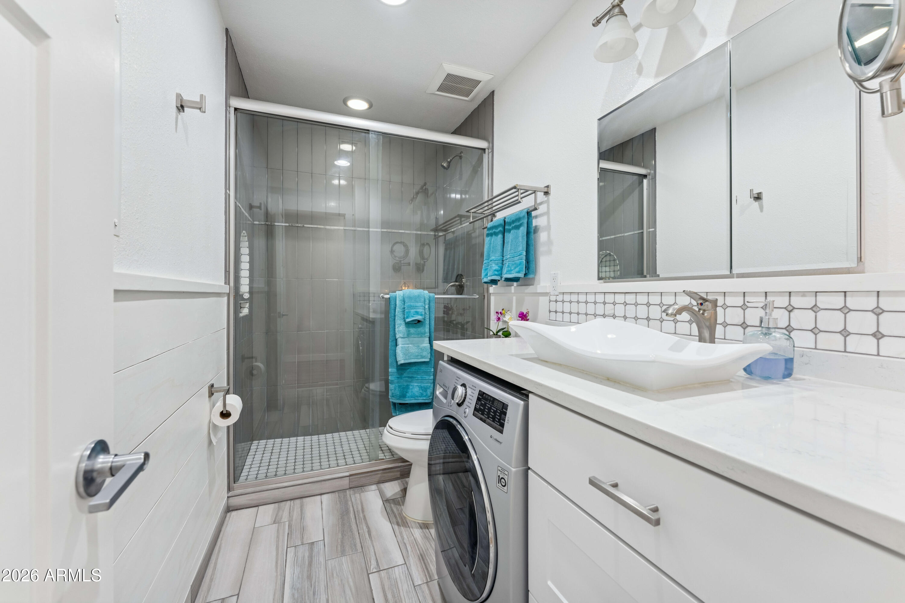 7436 East Chaparral Road, Unit B258 Scottsdale, AZ 85250 - Photo 3 of 23 a bathroom with a sink a washer and dryer