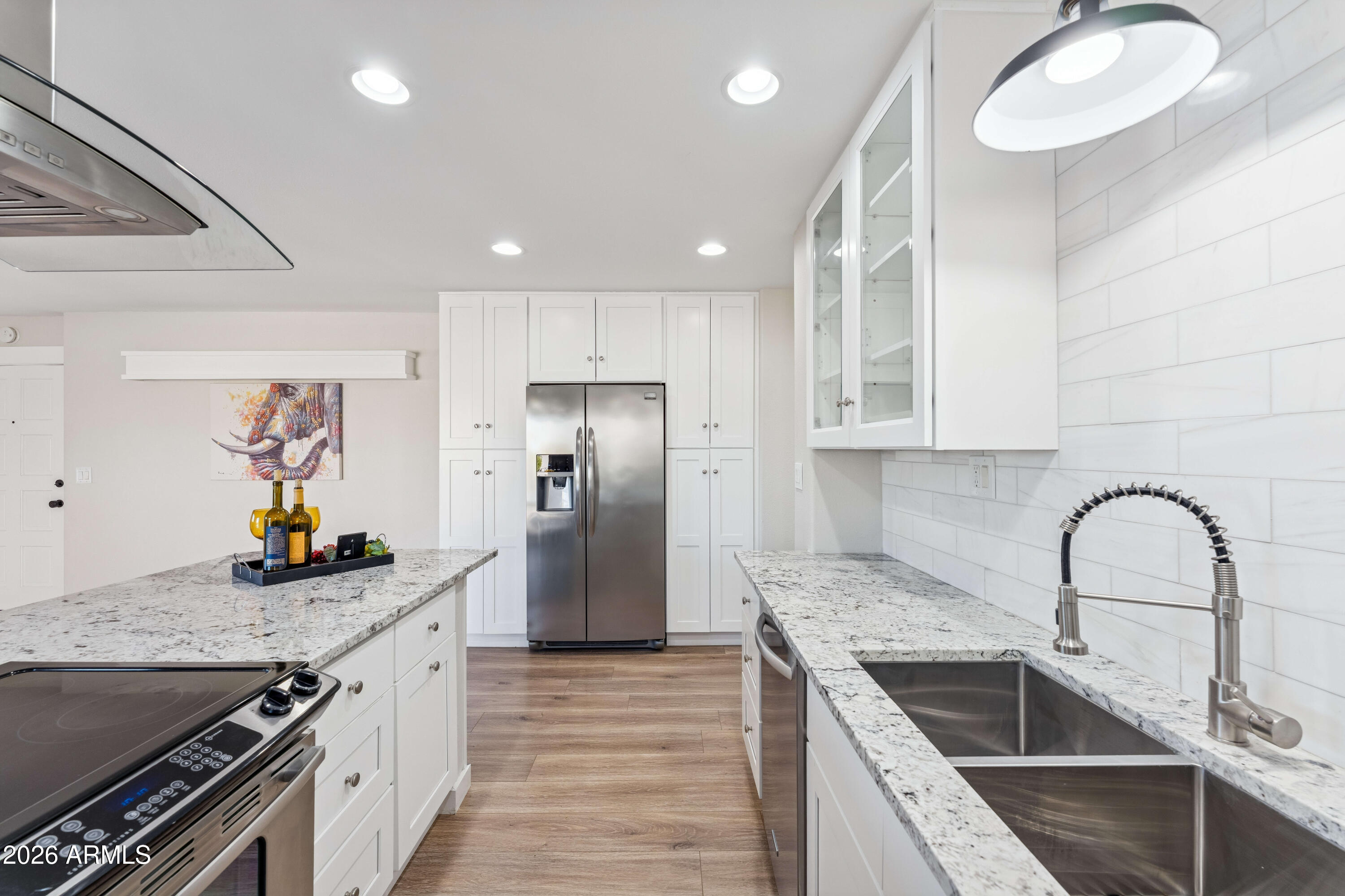 7436 East Chaparral Road, Unit B258 Scottsdale, AZ 85250 - Photo 9 of 23 a kitchen with granite countertop a sink stainless steel appliances and white cabinets