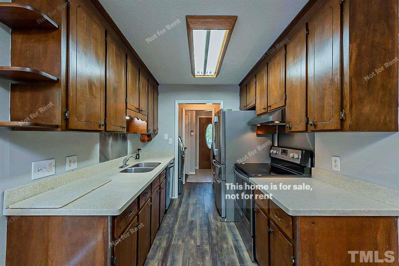 525 Rand Road Raleigh, NC 27603 - Photo 2 of 14 a kitchen with stainless steel appliances granite countertop a sink a stove and a refrigerator