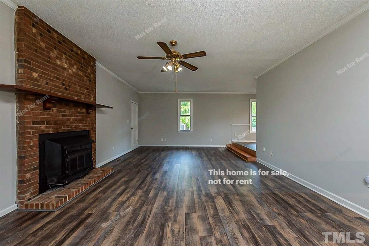 525 Rand Road Raleigh, NC 27603 - Photo 3 of 14 a view of empty room with wooden floor and fireplace