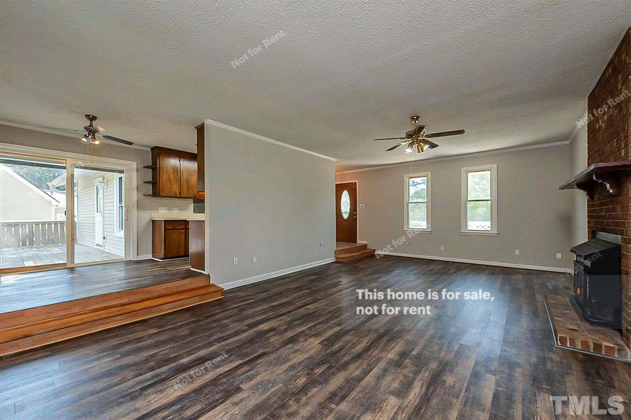 525 Rand Road Raleigh, NC 27603 - Photo 7 of 14 a view of a livingroom with wooden floor and a ceiling fan