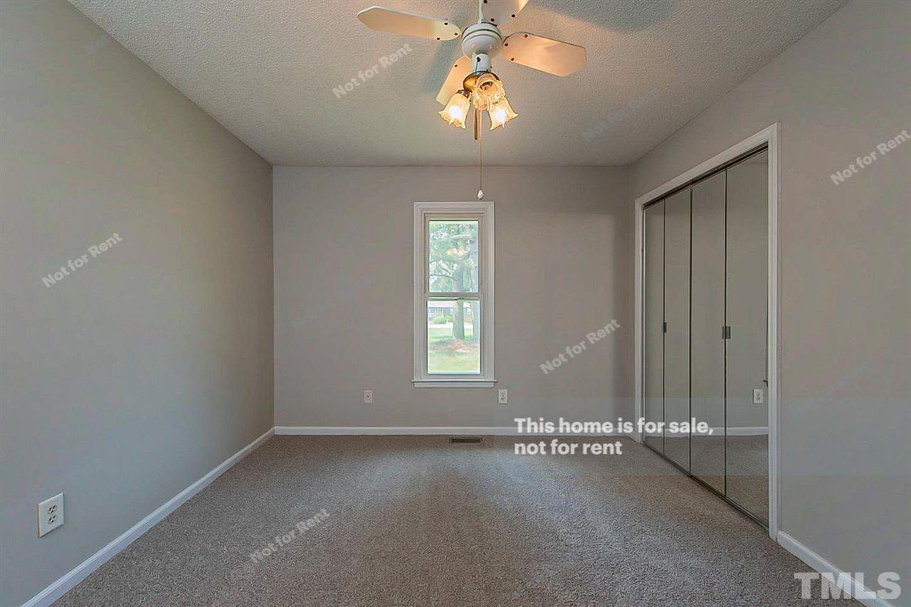 525 Rand Road Raleigh, NC 27603 - Photo 9 of 14 an empty room with a chandelier fan and windows