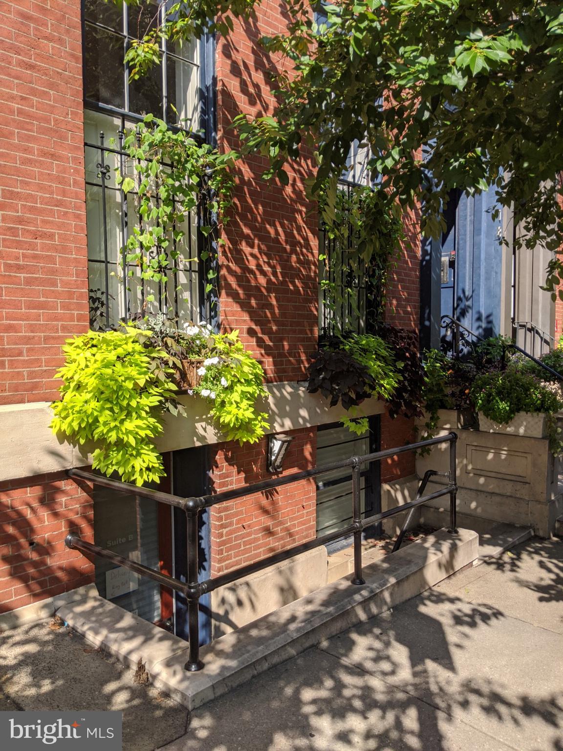 a street view with a bench and potted plants