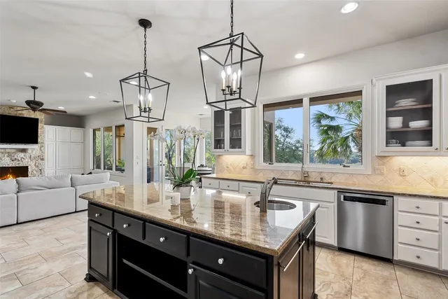 a kitchen with stainless steel appliances granite countertop a sink a stove and a wooden floors
