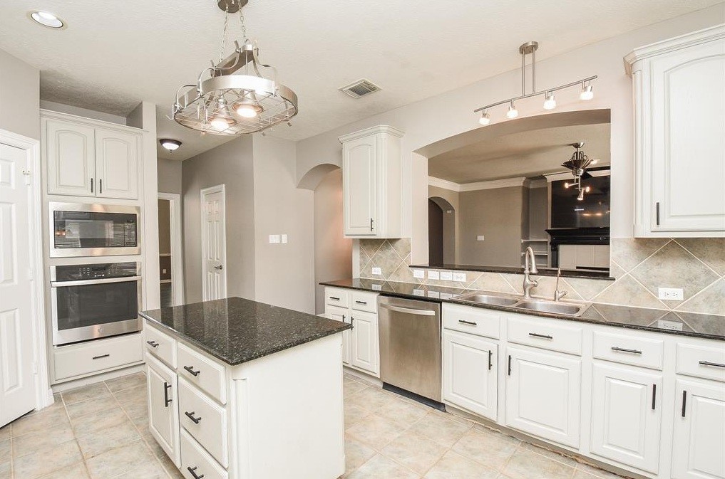 16522 Champions Cove Circle Spring, TX 77379 - Photo 11 of 30 a kitchen with stainless steel appliances granite countertop a sink and cabinets
