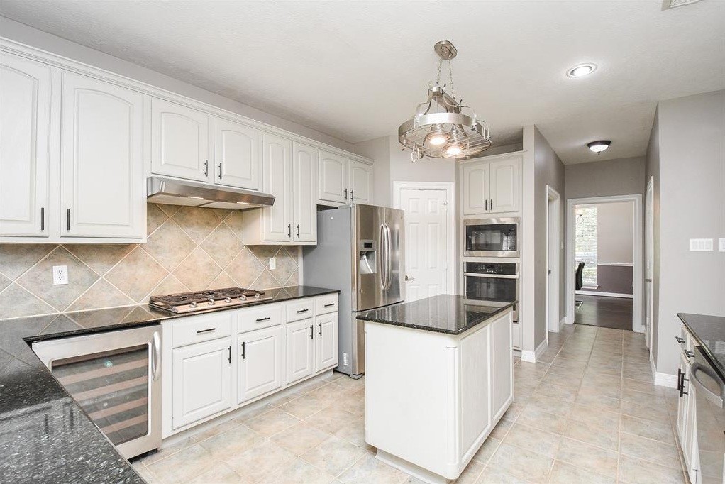 16522 Champions Cove Circle Spring, TX 77379 - Photo 12 of 30 a kitchen with stainless steel appliances a stove sink and refrigerator