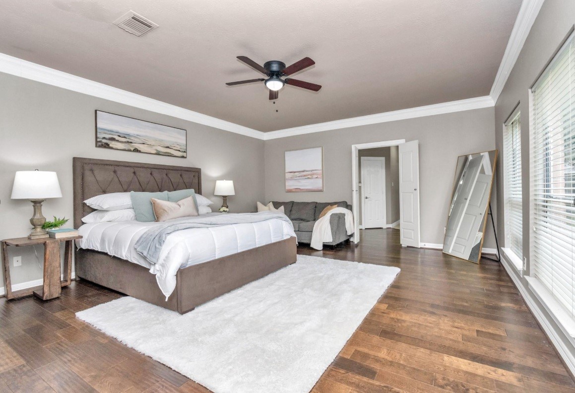16522 Champions Cove Circle Spring, TX 77379 - Photo 17 of 30 a bedroom with a large bed and a chandelier