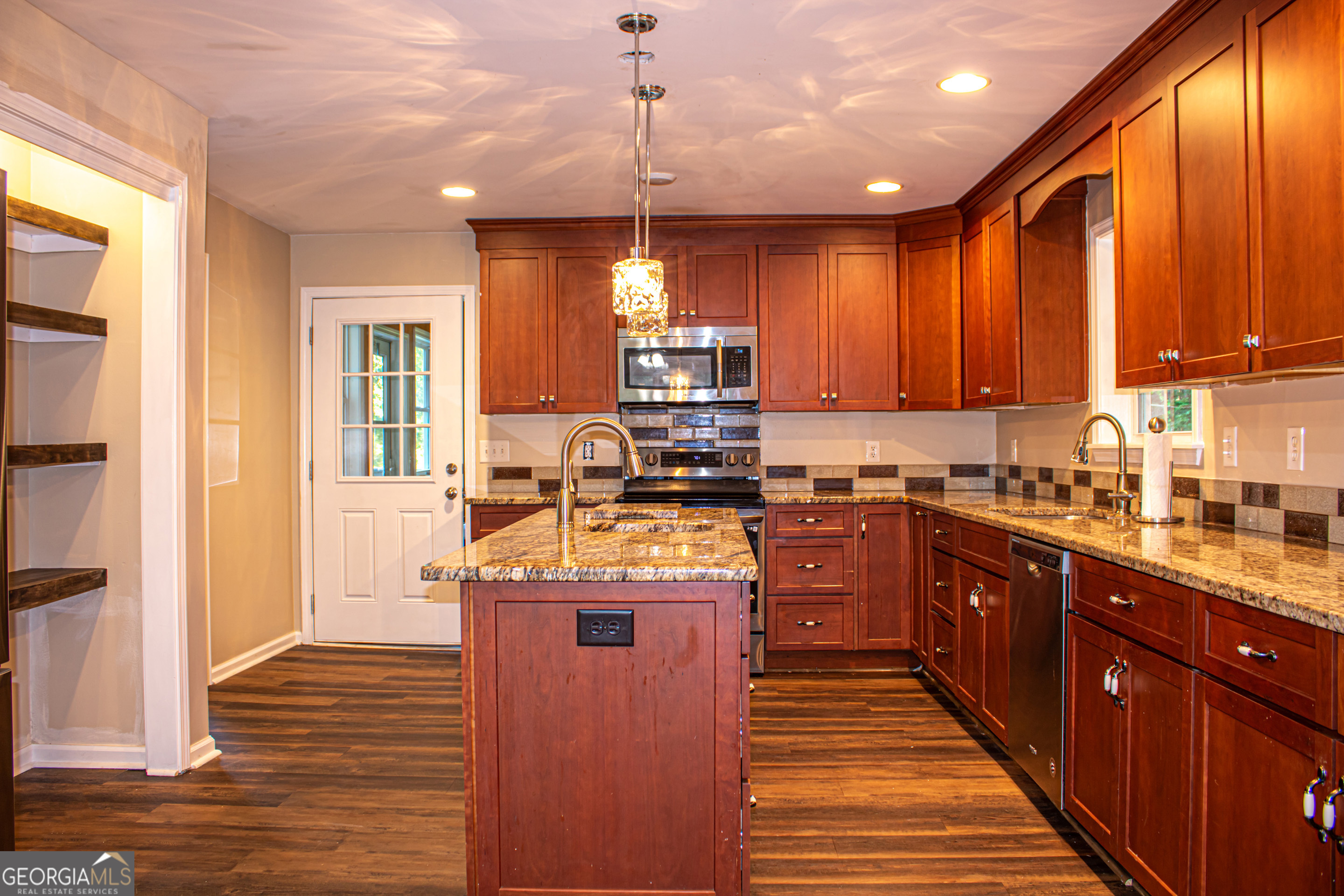 240 Harkness Road Jackson, GA 30233 - Photo 21 of 54 a kitchen with kitchen island granite countertop wooden cabinets and a stove