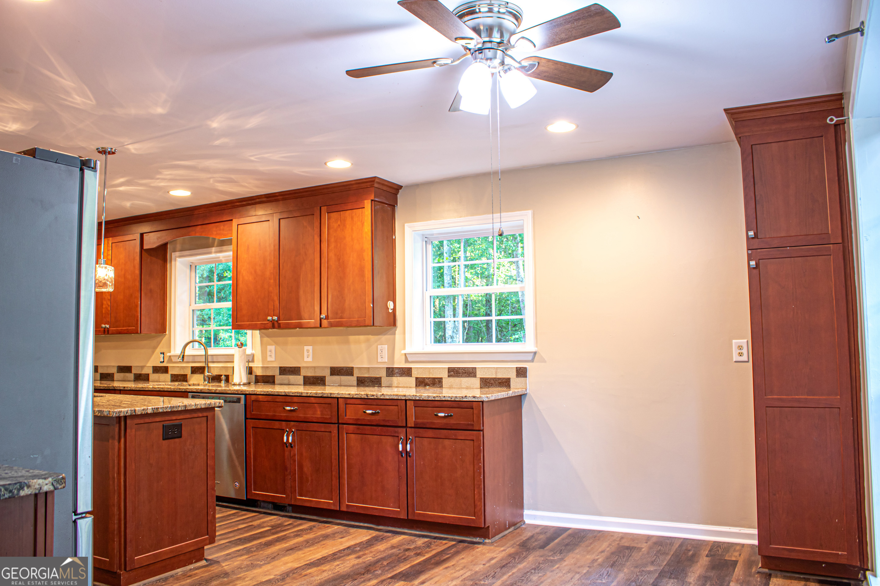 240 Harkness Road Jackson, GA 30233 - Photo 23 of 54 a kitchen with granite countertop a stove cabinets and wooden floor
