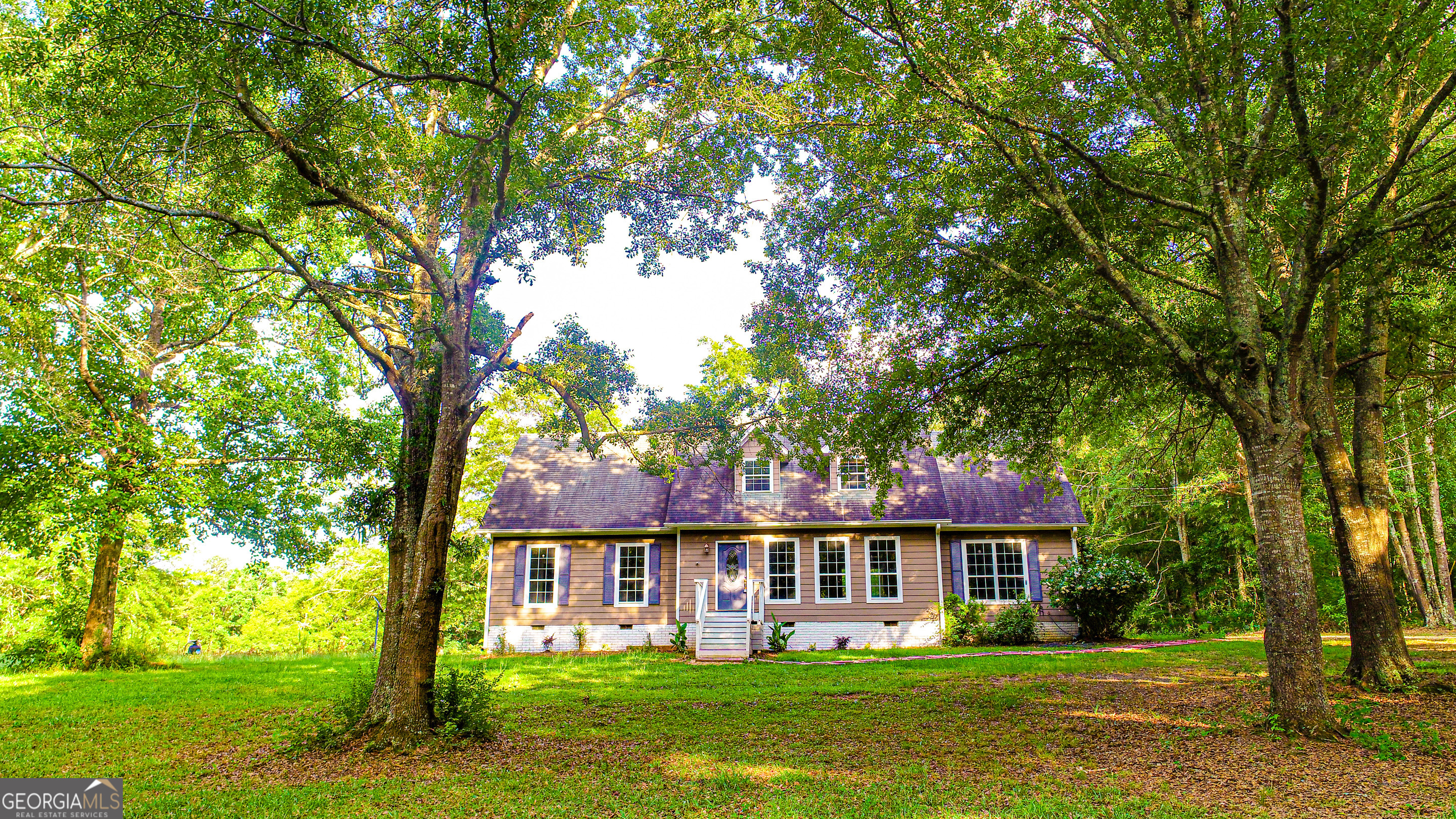 240 Harkness Road Jackson, GA 30233 - Photo 5 of 54 a front view of a house with a garden and trees