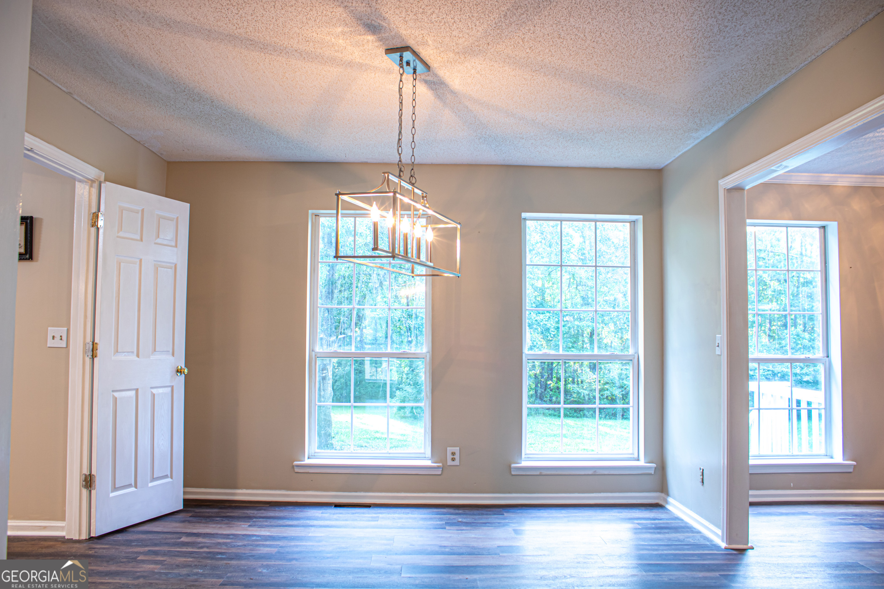 240 Harkness Road Jackson, GA 30233 - Photo 10 of 54 a view of an empty room with wooden floor fridge and a window