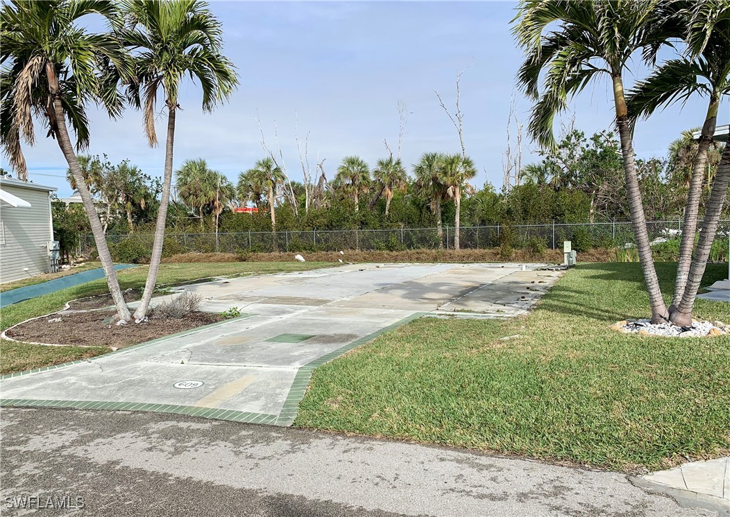 19681 Summerlin Road, Unit 609T Fort Myers, FL 33908 - Photo 1 of 20 a backyard of a house with palm trees