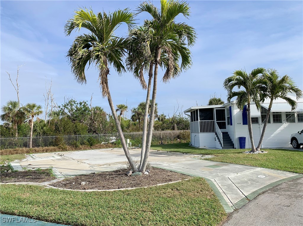 19681 Summerlin Road, Unit 609T Fort Myers, FL 33908 - Photo 12 of 20 a palm tree sitting in front of a house with a yard