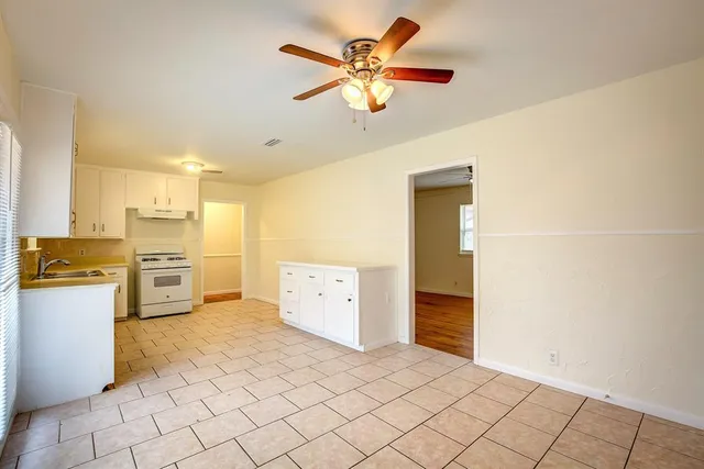 a kitchen with a refrigerator a stove top oven and cabinets