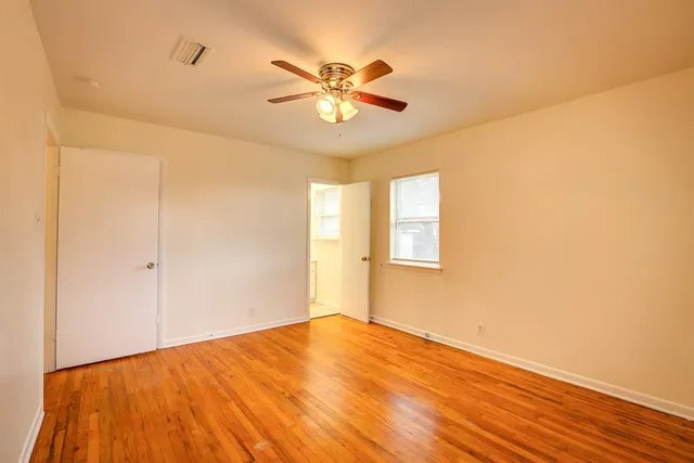 a view of a room with wooden floor and ceiling fan
