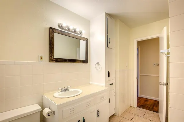 a bathroom with a granite countertop sink mirror and a toilet