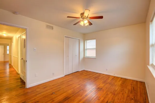 a view of a livingroom with wooden floor and a ceiling fan