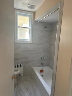 a bathroom with a tub a sink and a window