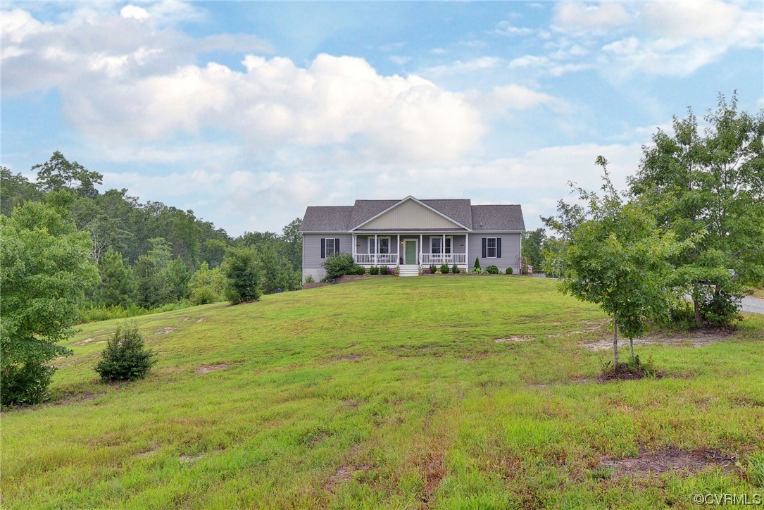 a view of a big house with a big yard and large trees