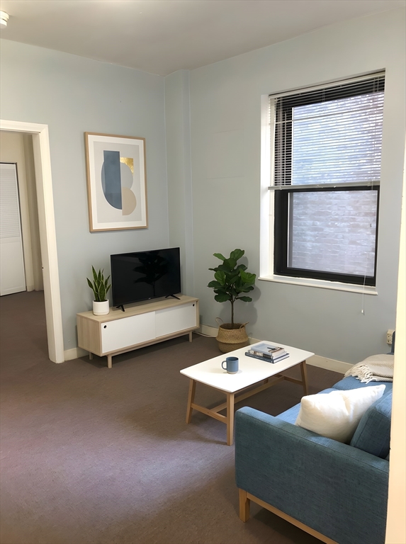 475 Commonwealth Avenue, Unit 304 Boston, MA 02215 - Photo 3 of 8 a living room with furniture and window