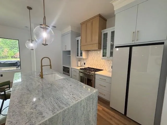 a view of a kitchen with kitchen island a sink and wooden floor