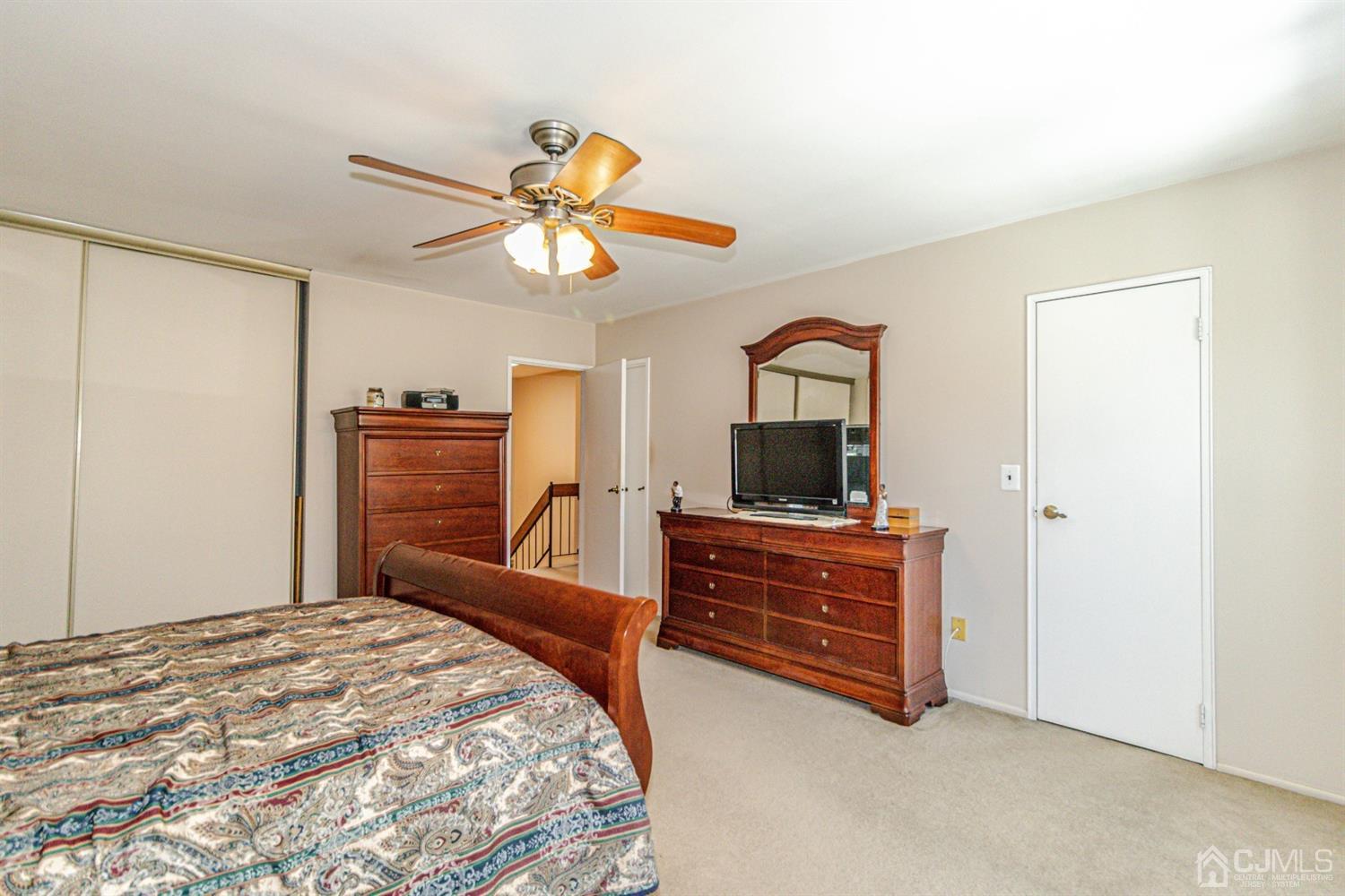 6803 Hana Road Edison, NJ 08817 - Photo 15 of 25 a bedroom with a bed and a flat screen tv