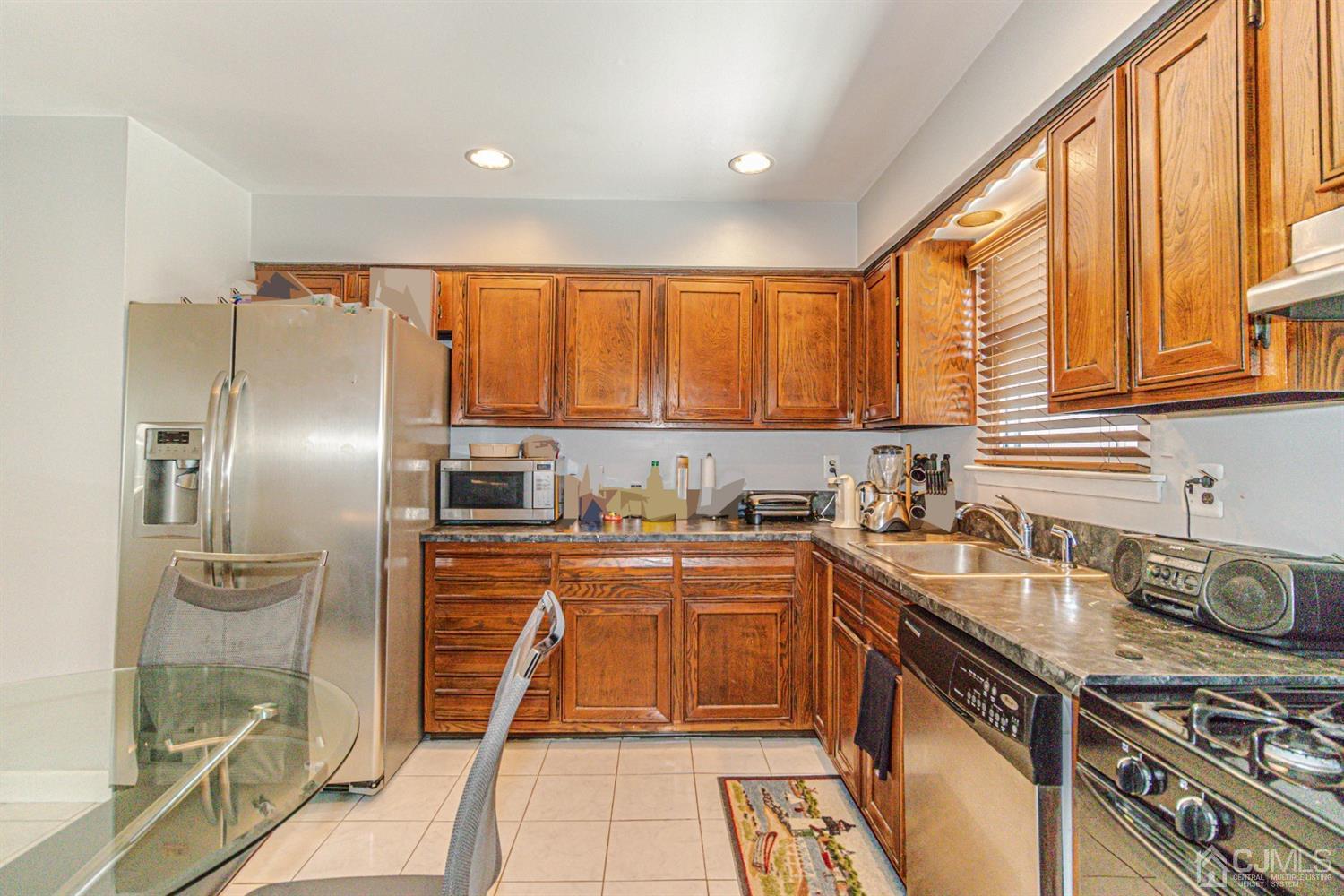 6803 Hana Road Edison, NJ 08817 - Photo 3 of 25 a kitchen with granite countertop a sink stainless steel appliances and cabinets