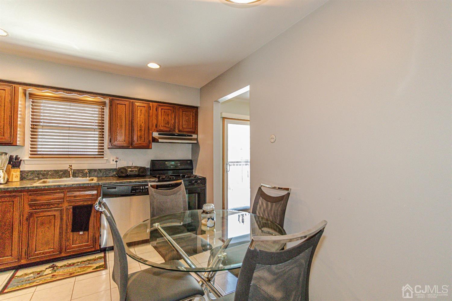 6803 Hana Road Edison, NJ 08817 - Photo 4 of 25 a kitchen with stainless steel appliances granite countertop a stove top oven a sink a dining table and chairs