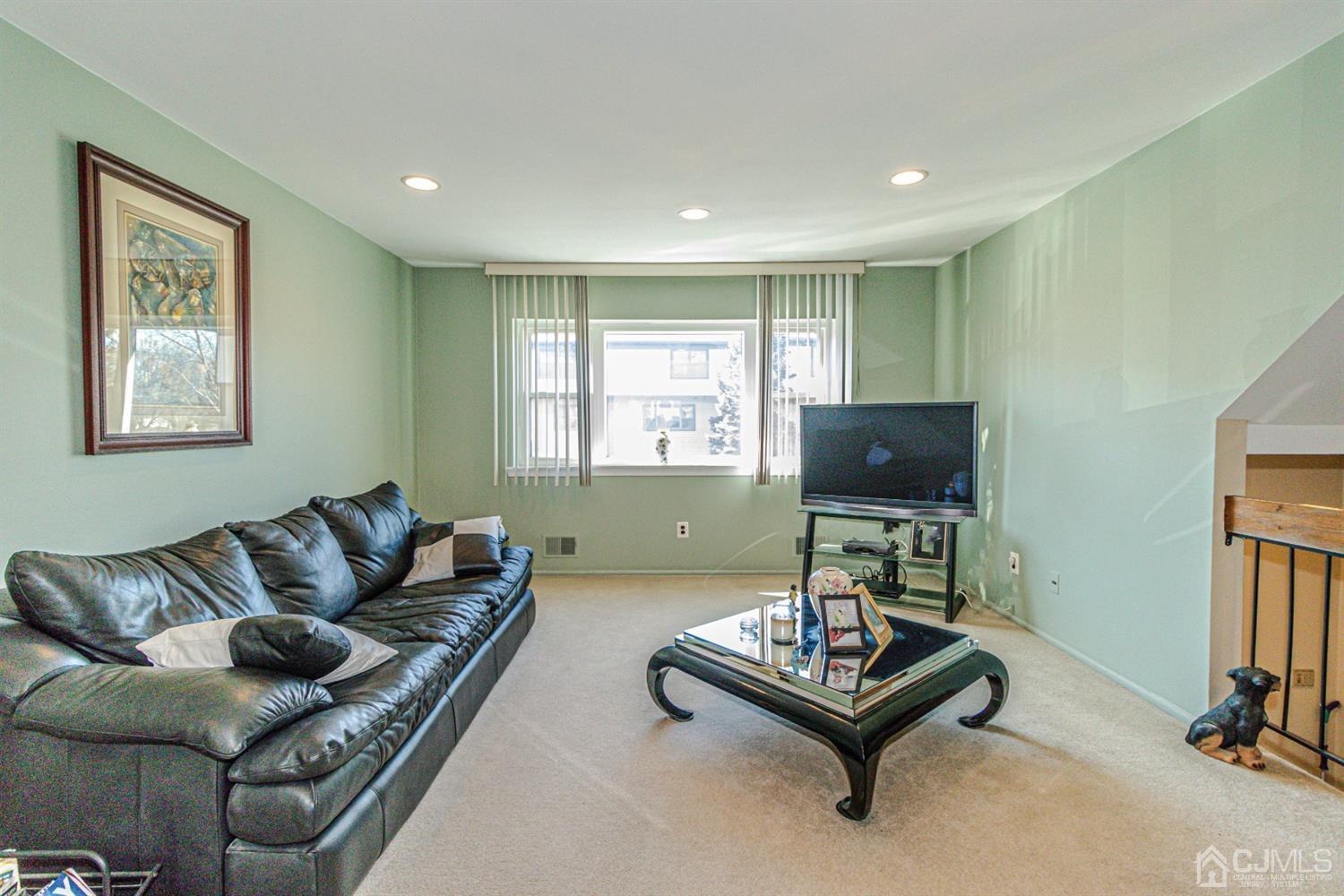 6803 Hana Road Edison, NJ 08817 - Photo 9 of 25 a living room with furniture and a flat screen tv